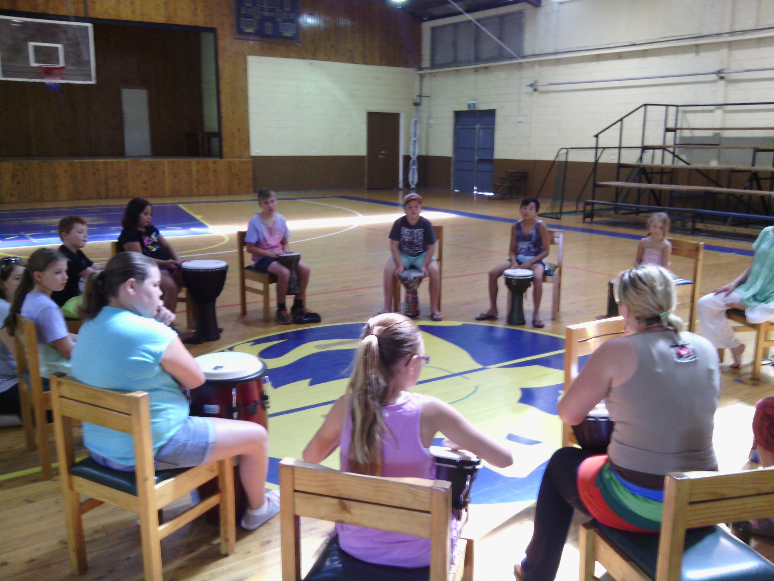 Young people seated in a circle with drums