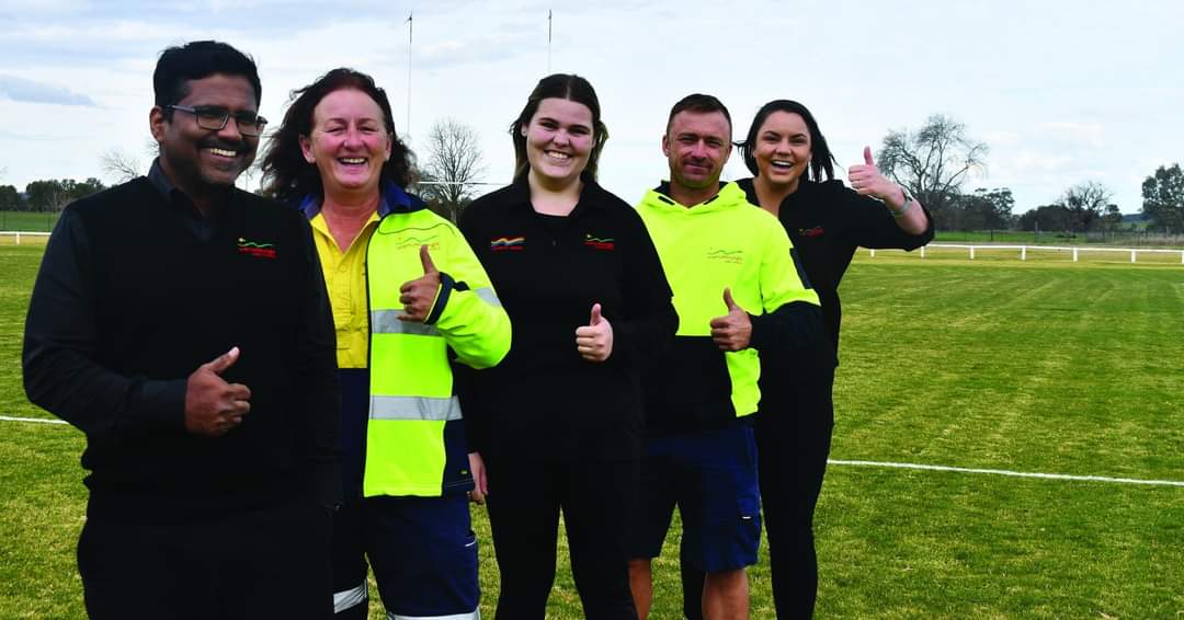 Diverse council staff standing on sporting field