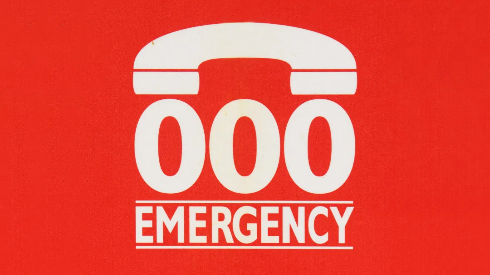 old style phone with triple zero and emergency under it on red background