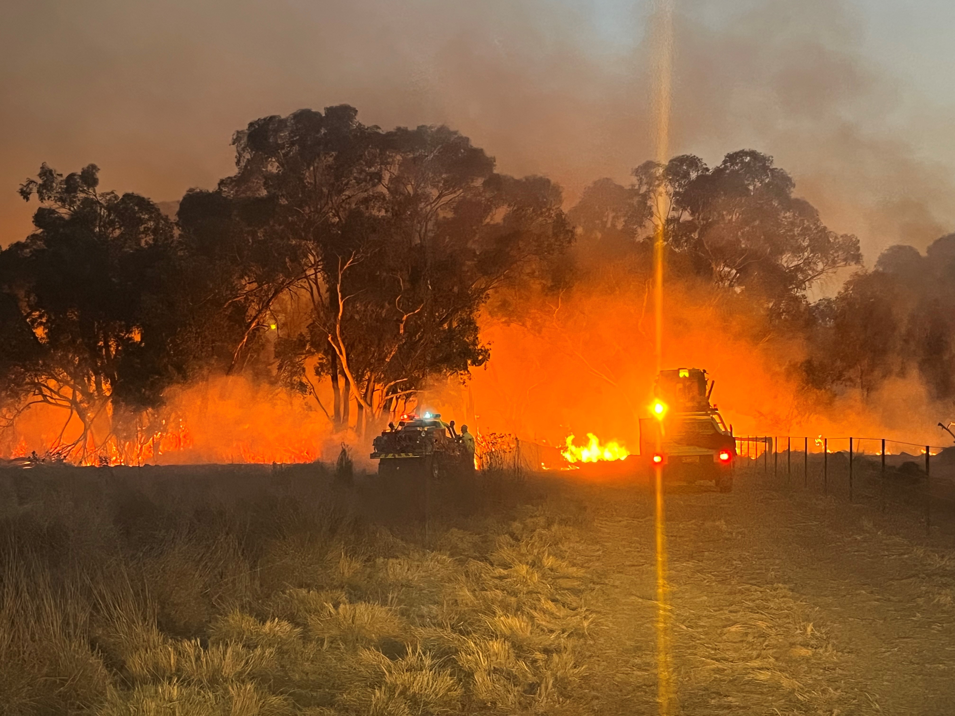 fire on property with emergency services vehicle and council grader